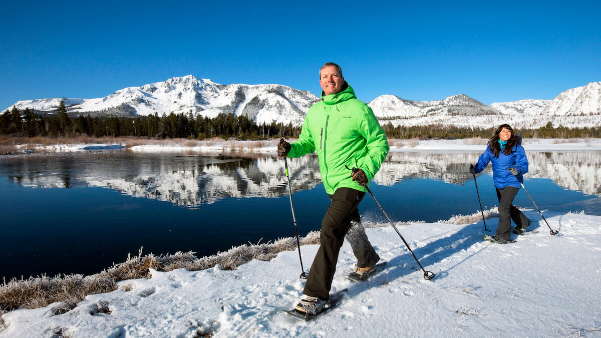 Couple snowshoeing at Kiva Beach with Mt Tallac in background