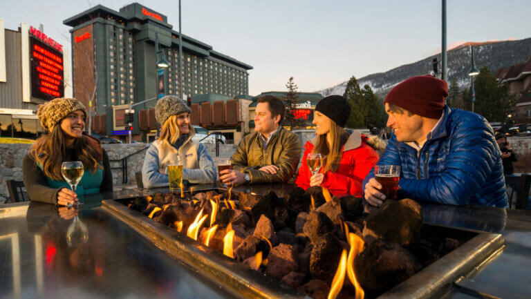 Friends having apres drinks by a firepit at Stateline