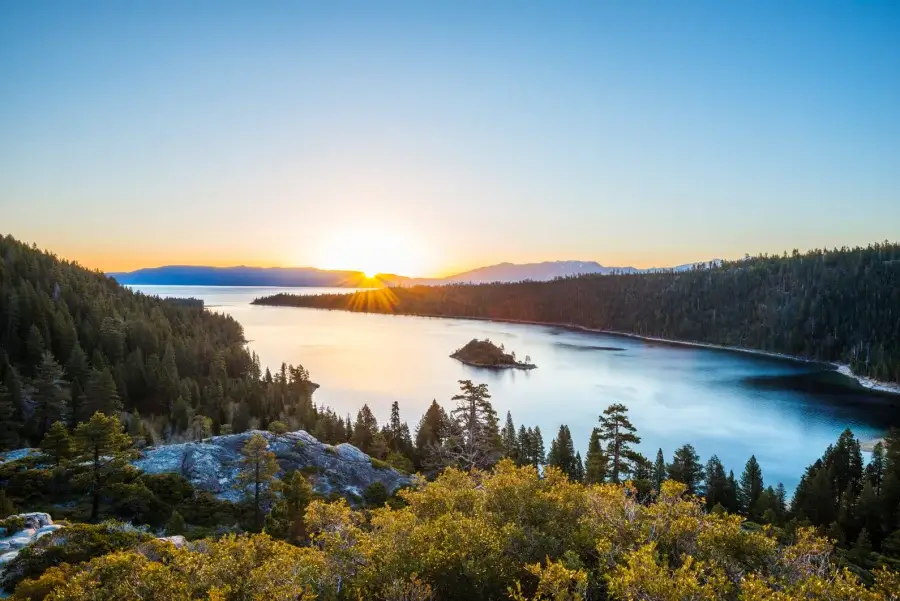 Looking down at Emerald Bay with water like glass and the reflection of the mountains at sunrise